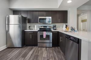 una cocina con electrodomésticos de acero inoxidable y armarios de madera en Cute Santa Monica Apartment with Pool en Los Ángeles