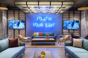 a lobby with couches and a blue wall with follow your heart at Aloft by Marriott Playa del Carmen in Playa del Carmen