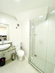 uma casa de banho com um WC e uma cabina de duche em vidro. em Residencial Gaivotas 13 - 1 Quartos - Apartamento completo, 70m da praia em Florianópolis