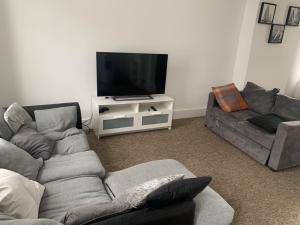 ein Wohnzimmer mit einem Sofa und einem Flachbild-TV in der Unterkunft Double bedroom in Portsmouth