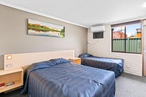 A bed or beds in a room at Morayfield Tavern