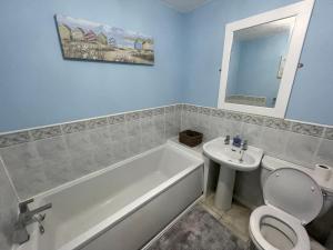 ein Badezimmer mit einer Badewanne, einem WC und einem Waschbecken in der Unterkunft Quiet 3 bed home in Stafford