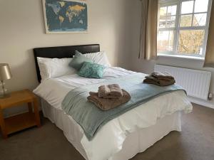 ein Schlafzimmer mit einem Bett mit Handtüchern darauf in der Unterkunft Quiet 3 bed home in Stafford