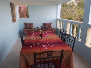 a dining room with a table with flowers on it at Dar Lala Zhour in Aïn Bouchrik