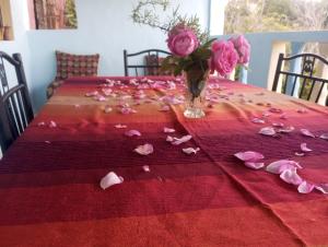 einen Tisch mit rosa Rosen und eine Vase Blumen in der Unterkunft Dar Lala Zhour in Aïn Bouchrik