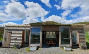 une petite maison en bois avec un toit en gazon dans l'établissement Calon Y Goedwig Glamping, à Llandovery