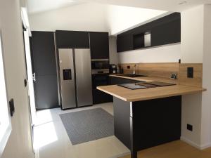 a kitchen with black and white cabinets and a refrigerator at Villa STEVAN in Bonifacio +7 photos
