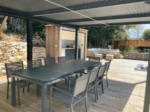 a patio with a black table and chairs on a deck at Villa STEVAN in Bonifacio