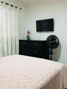 麥德林的住宿－Hospedaje juandi，一间卧室配有一张床和一台平面电视