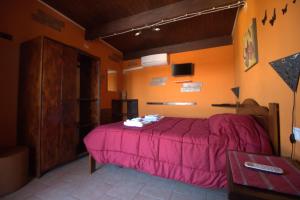 - une chambre avec un lit doté d'un couvre-lit rose dans l'établissement la terrazza, à Quartu SantʼElena