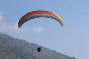 a person riding a parachute in the sky at Aaren's abobe in Kulu