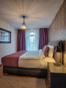 a bedroom with a large bed with purple curtains at or'o apartments in Žabljak