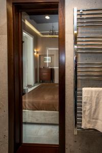 a mirror in a bathroom with a bed in a room at Xenia Neapolis in Naples