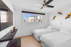 a bedroom with two beds and a ceiling fan at MS Suite Ubicadisima Comodidad Homeoffice A33 in Casa Blanca La Corregidora