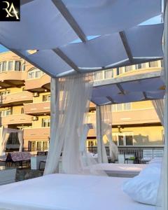 a bed with a canopy in front of a building at Accommodation Royal Azur in Dobra Voda