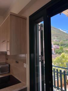 a kitchen with a sliding glass door to a balcony at Reis Villa in Nikiana