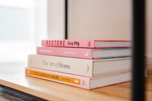 une pile de livres assis sur une table dans l'établissement Cosy & Stylish Apmt w/ Fast Wifi, à Londres