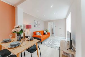 - un salon avec un canapé orange et une table dans l'établissement Cosy & Stylish Apmt w/ Fast Wifi, à Londres