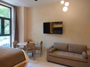 a bedroom with a bed and a couch and a table at Confortable Studio in the heart of Mexico in Mexico City