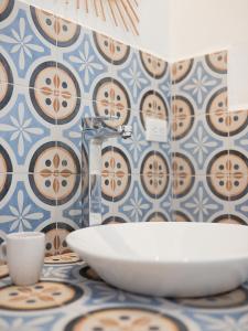 a bathroom with a sink and blue and white tiles at Olivia del caribe suite in Puerto Viejo