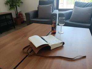 un libro abierto sobre una mesa de centro con una copa de vino en Finca La Caprichosa, en Cortelazor