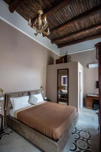 a bedroom with a bed and a chandelier at Xenia Neapolis in Naples