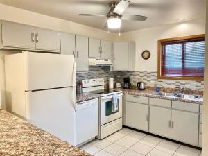 a kitchen with white appliances and a white refrigerator at Dells Getaway At Tamarack & Mirror Lake Resort in Wisconsin Dells