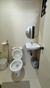 y baño con aseo, lavabo y espejo. en TheHideawaybyKG/Angono, en Angono