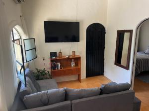 sala de estar con sofá y TV de pantalla plana en Casita tranquila, en Sayulita