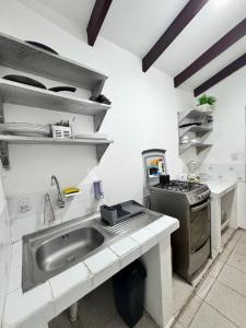 a kitchen with a sink and a stove at Acogedor independiente-Casa JH B in Santa Cruz de la Sierra