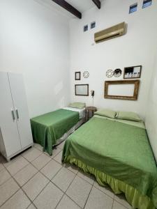 Dos camas en una habitación con sábanas verdes. en Acogedor independiente-Casa JH B, en Santa Cruz de la Sierra 5 fotos más