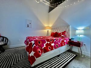 a bedroom with a bed with a red and white comforter at Kings Island Loft with Brewery, River, and Bike Trail in Maineville