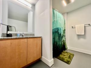 a bathroom with a sink and a large painting on the wall at Kings Island Loft with Brewery, River, and Bike Trail in Maineville