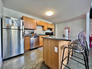 a kitchen with stainless steel appliances and wooden cabinets at Kings Island Loft with Brewery, River, and Bike Trail in Maineville