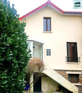 Ô Cottage La Barre Ormesson - 20 min Paris في Deuil-la-Barre: بيت ابيض امامه درج