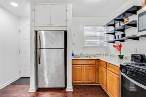uma cozinha com frigorífico e armários de madeira em Pao and Pui em Kenner