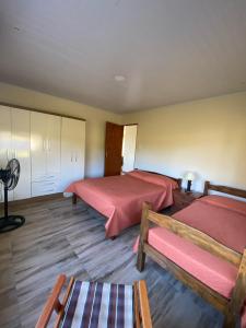 a bedroom with two beds and a fan at El Lirio in Artigas