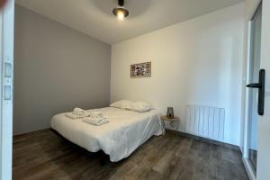 een slaapkamer met een bed met twee handdoeken erop bij Splendid new house in Ouistreham in Ouistreham