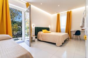 a bedroom with a bed and a balcony with yellow curtains at Villa Talia in Sorrento