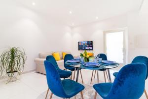 a living room with a table and blue chairs at Villa Talia in Sorrento