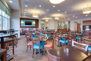 uma sala de jantar cheia de mesas e cadeiras em Drury Inn & Suites Charlotte Arrowood em Charlotte