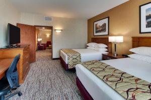 a hotel room with two beds and a flat screen tv at Drury Inn & Suites Meridian in Meridian