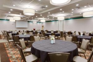 uma sala de conferências com mesas e cadeiras e um ecrã em Drury Inn & Suites Charlotte Arrowood em Charlotte