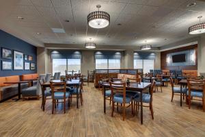 uma sala de jantar com mesas e cadeiras de madeira em Drury Inn & Suites Iowa City Coralville em Coralville