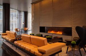 a living room with a couch and a fireplace at art'otel London Hoxton, Powered by Radisson Hotels in London