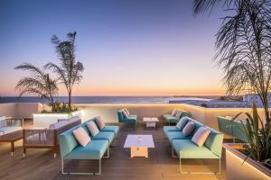 un patio del hotel con sillas y vistas al océano en Barceló Conil Playa - Adults Recommended, en Conil de la Frontera