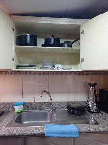 eine Küchenspüle mit Töpfen und Pfannen auf einem Regal in der Unterkunft DEPARTAMENTO completo cercano a muchos lugares in Huamboya