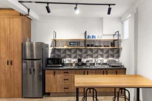 a kitchen with a stainless steel refrigerator and a table at MS Moderna Suite Arcos Hercules HD1 in Laborcillas