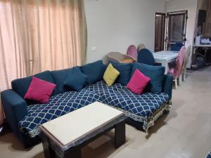 a living room with a blue couch with colorful pillows at قرية بلو باي اسيا السخنة blue bay in Ain Sokhna
