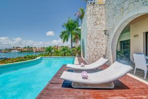 una piscina con 2 tumbonas y un osito de peluche en FISHING LODGE, INFINITY POOL, VISTAS A LA BAHIA, en Punta Cana
